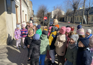 Dzieci oglądają tablicę informacyjną o Św. Faustynie