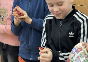 Dzieci zgniatają papierowe kartki