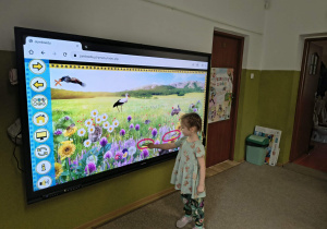 dziecko zaznacza na tablicy oznaki wiosny