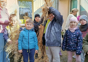 Robimy Marzannę ze słomy na przedszkolnym tarasie.