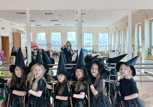 Dziewczynki w przebraniach czarownic grupowe przed festiwalem piosenki i tańca.