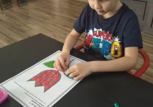Filip z grupy 5 wykleja kwiat plasteliną