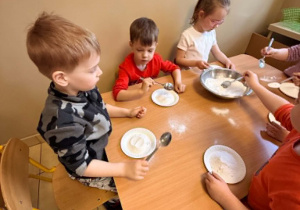 Dzieci wykonują eksperymenty.