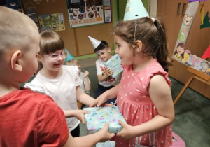 Liwia i Maciek wręczają prezent Hani