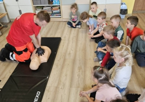 Ratownik pokazuje jak prawidłowo wykonać resuscytacje