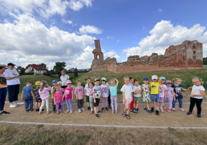 Dzieci pozują na tle ruin zamku.