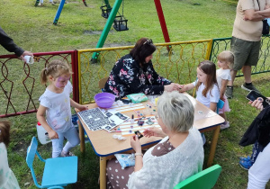 Piknik rodzinny- dzieci ozdabiają magnesy.