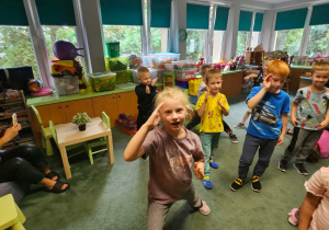 Zabawa ruchowa na dywanie - dzieci wykonują wskazane przez instruktorkę gesty.