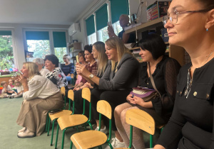 Pracownicy przedszkola oglądają występ z okazji Dnia Edukacji Narodowej.