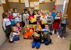 Zdjęcie grupowe - dzieci z grupy III ze zgromadzoną karmą dla zwierząt.