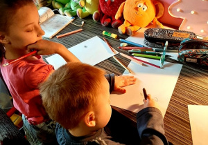 Mikołajowi z grupy 1 w rysowaniu pomaga siostra
