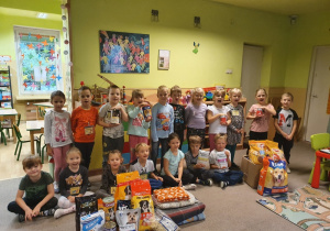 Zdjęcie grupowe dzieci ze zgromadzonymi produktami.