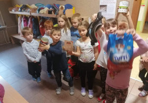 Dzieci trzymają worki z karmą dla zwierząt.