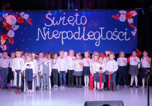 Dzieci tańczą ze wstążkami biało -czerwonymi.