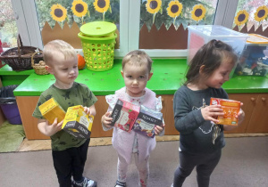 Dzieci trzymają pudełka z herbatami.