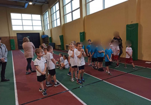 Dzieci biorą udział w konkurencji sportowej - skok w dal.