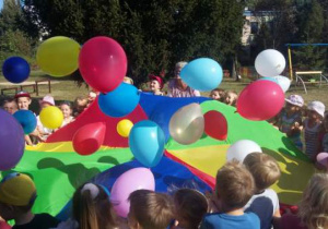 Zabawa z kolorowymi balonami w ogrodzie