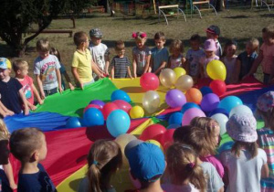 Zabawa z kolorowymi balonami w ogrodzie