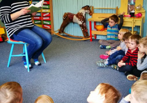 Pani Justyna czyta, dzieci siedzą na dywanie
